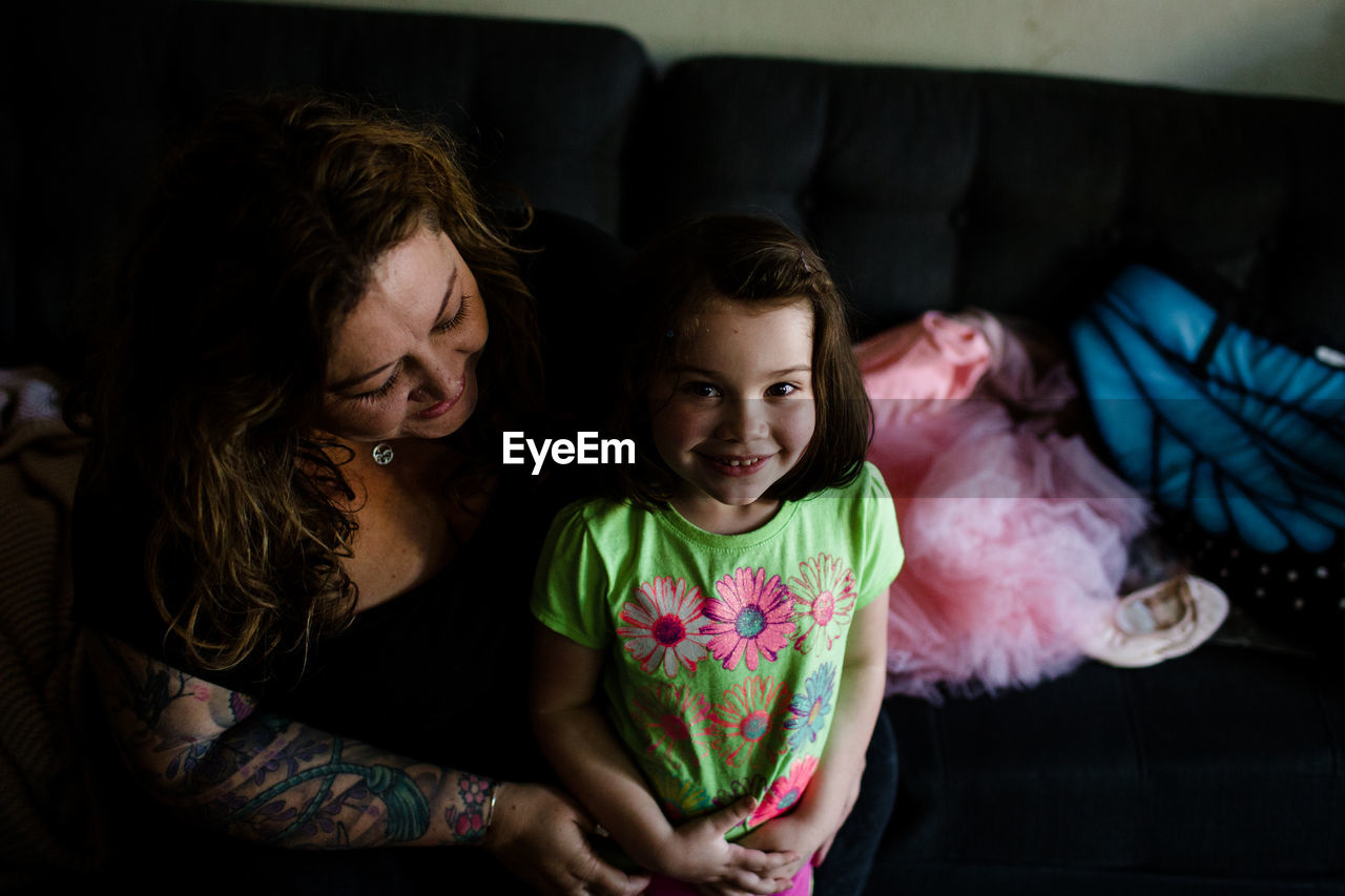 Niece and aunt sitting on couch, smiling