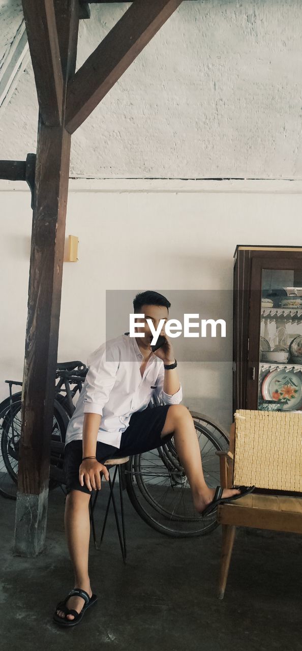 Full length of young man sitting on chair