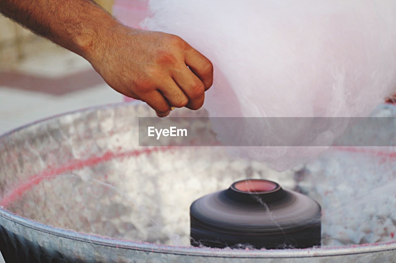 Cropped image of man making cotton candy