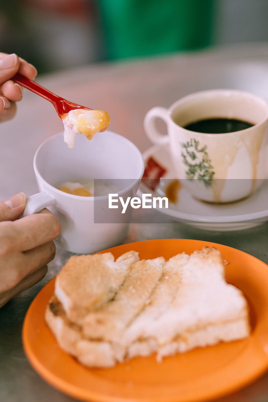 Close-up of hand holding eating food on table