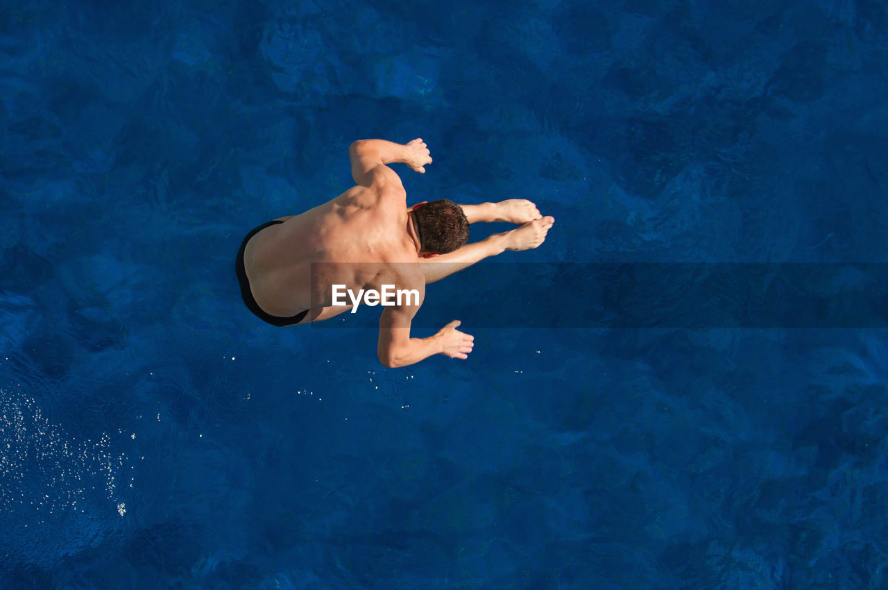 Directly above shot of man jumping in swimming pool