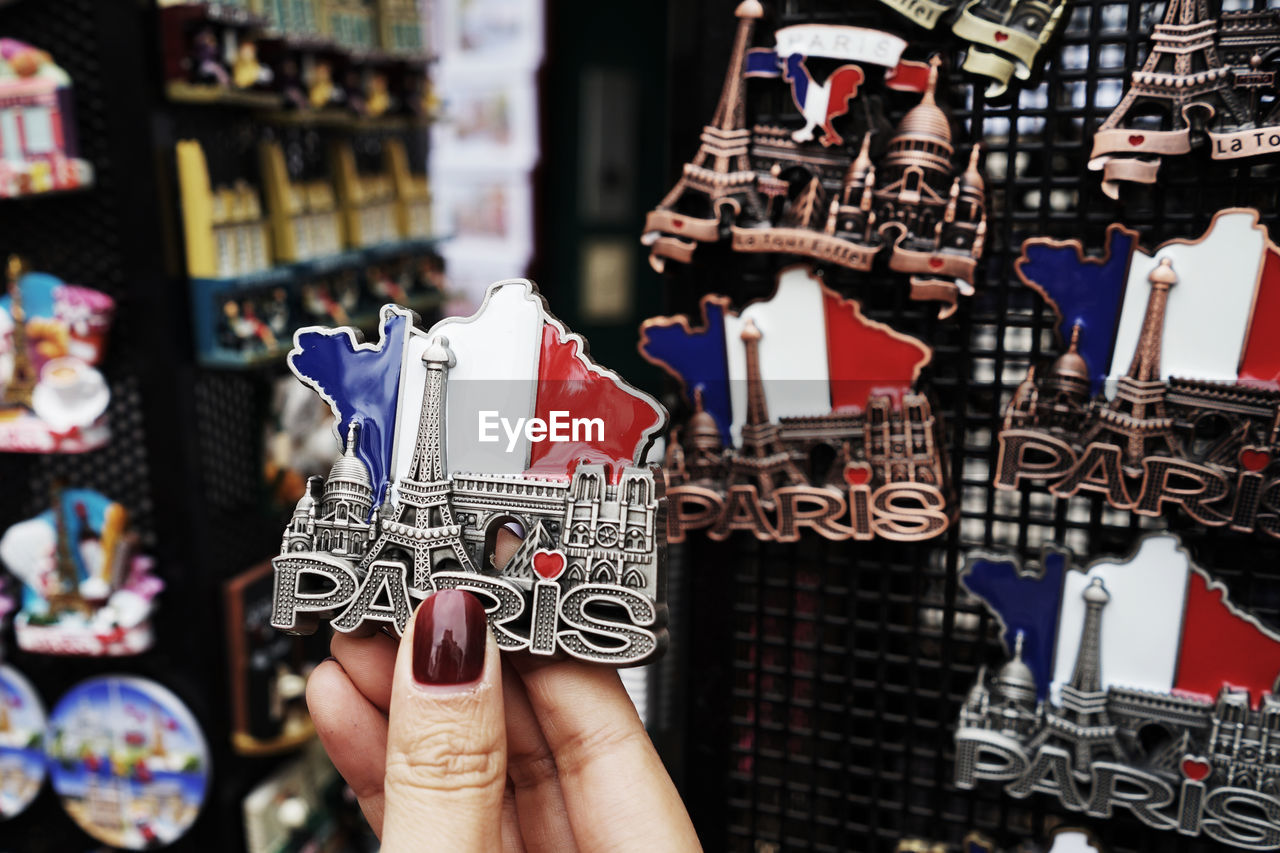 Cropped hand of woman holding souvenir in store