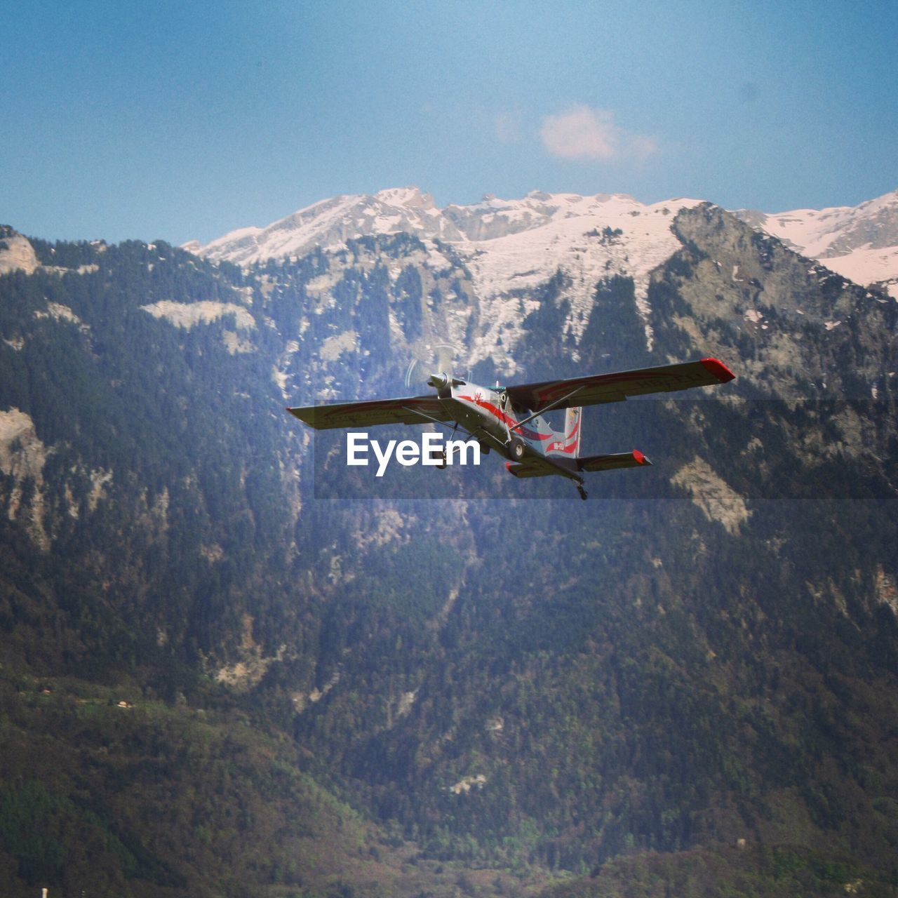 Seaplane flying against mountains