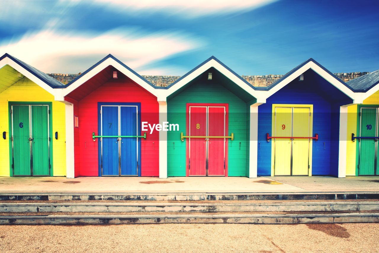 COLORFUL BEACH HUTS AGAINST BUILDINGS