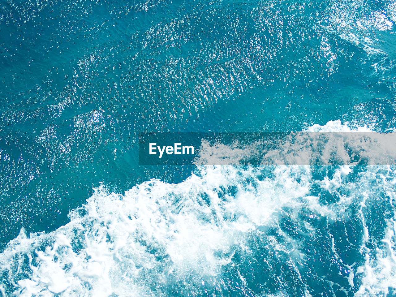 HIGH ANGLE VIEW OF SEA WAVES SPLASHING ON SHORE