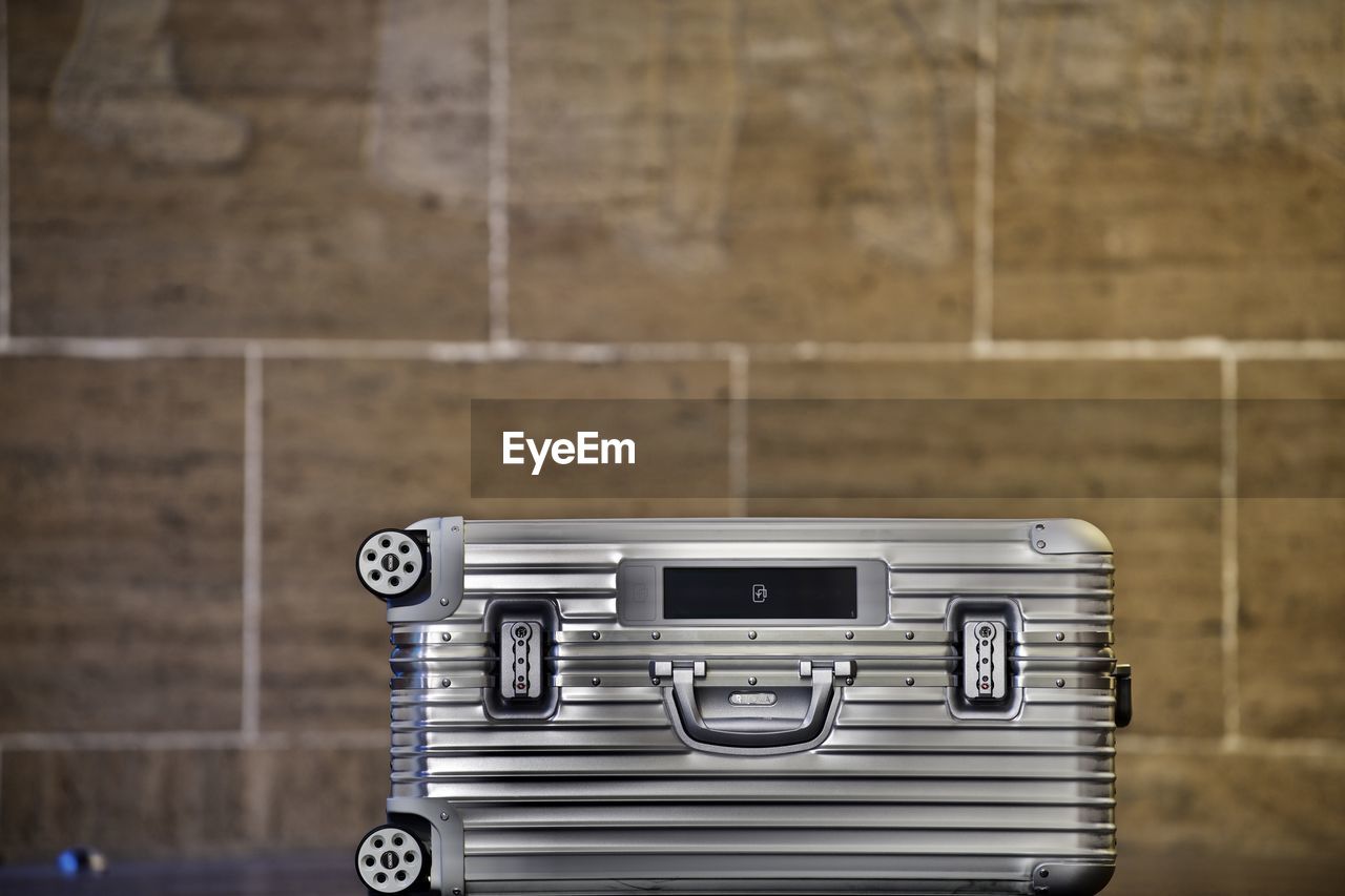 Close-up of suitcase against wall