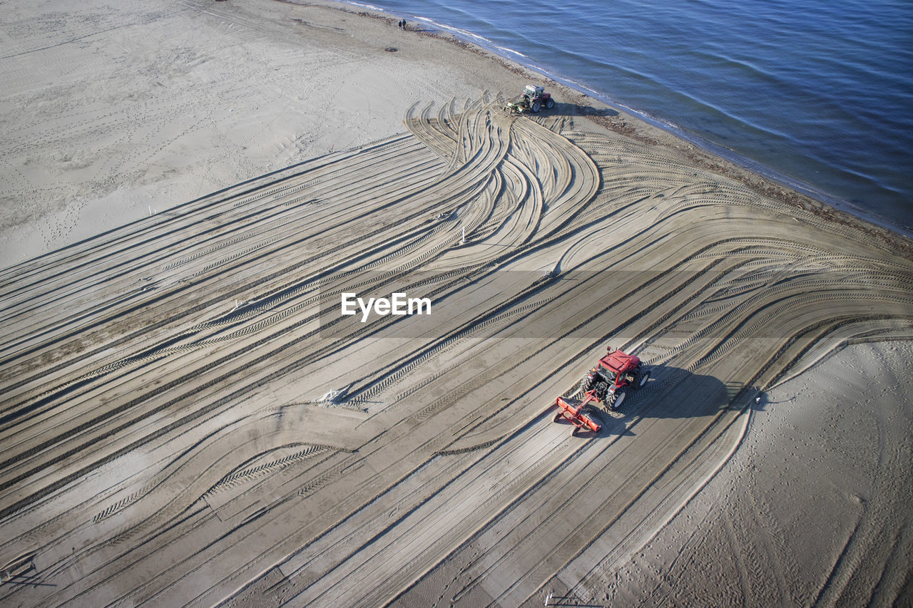 High angle view of tractors on sand at beach