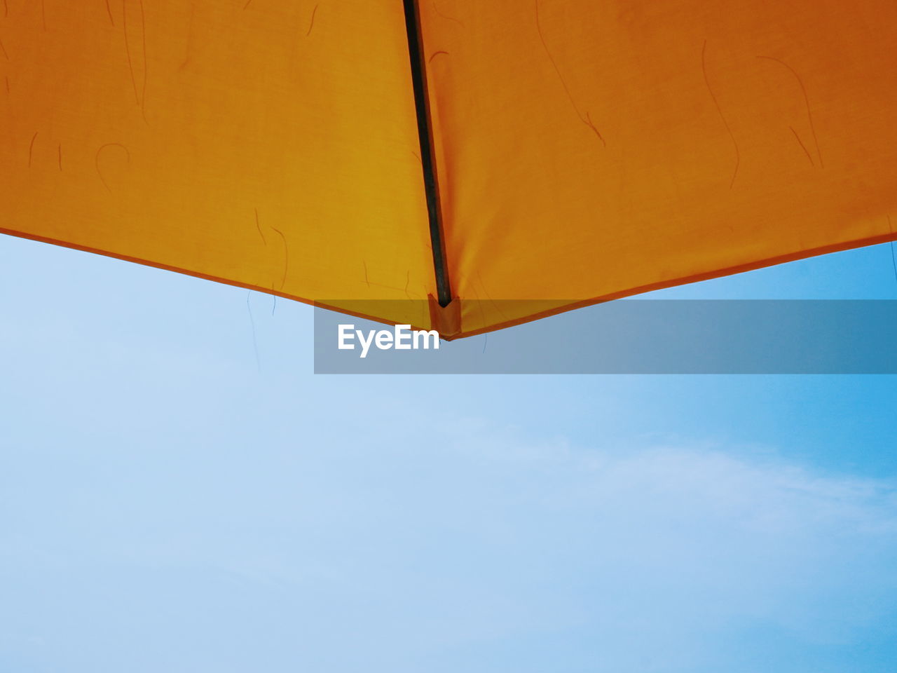 Cropped image of yellow umbrella against sky