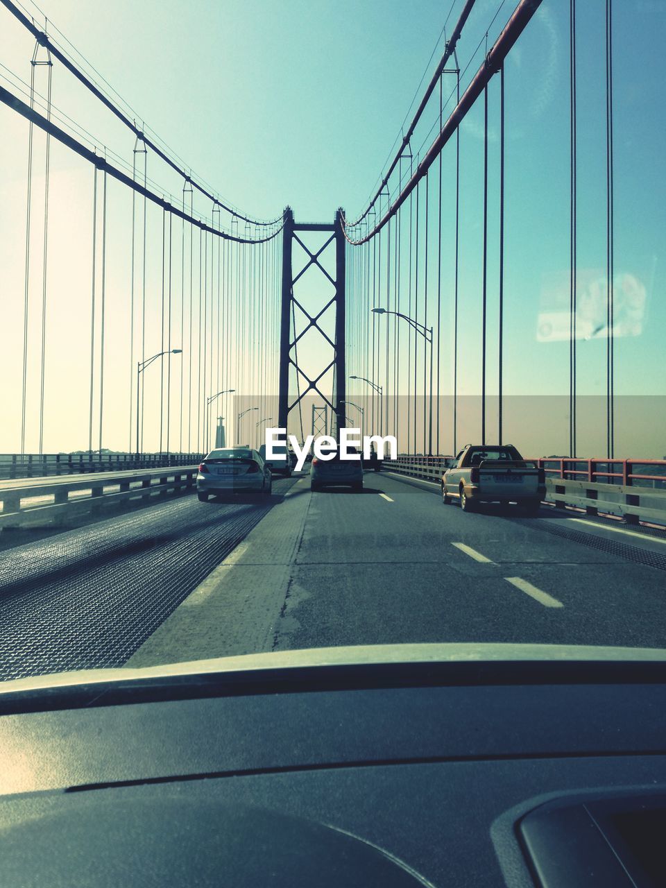 VEHICLES ON SUSPENSION BRIDGE AGAINST CLEAR SKY