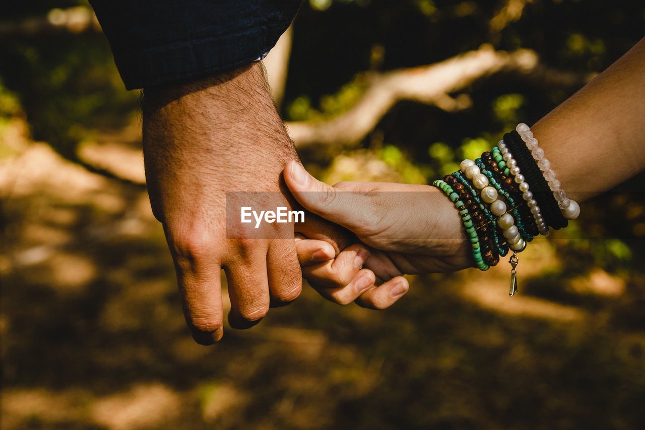 Cropped image of couple holding hands