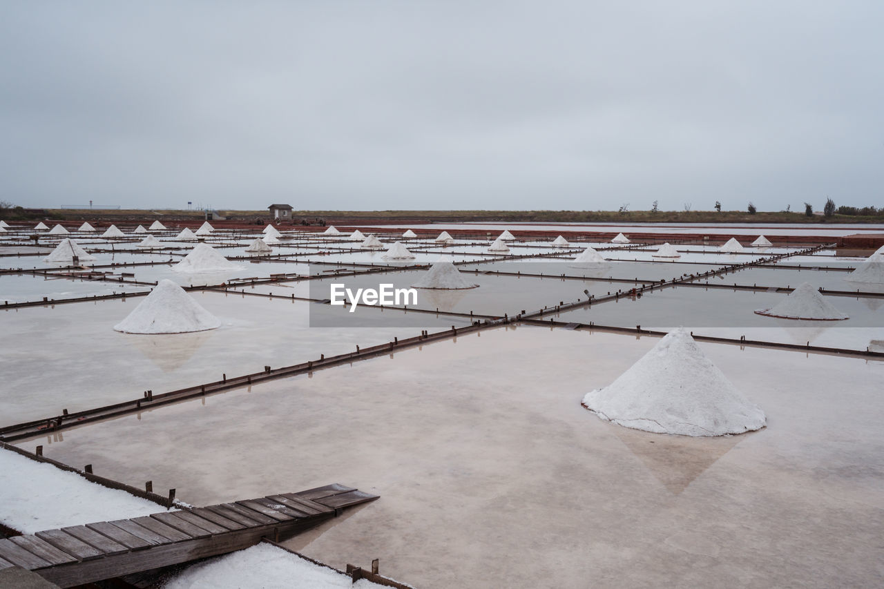 Jingzaijiao tile paved salt fields with dry salt ready for harvesting in cloudy weather in tainan city in taiwan
