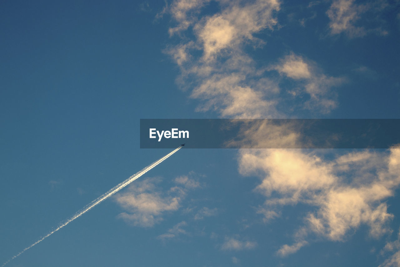 LOW ANGLE VIEW OF AIRPLANE FLYING AGAINST BLUE SKY