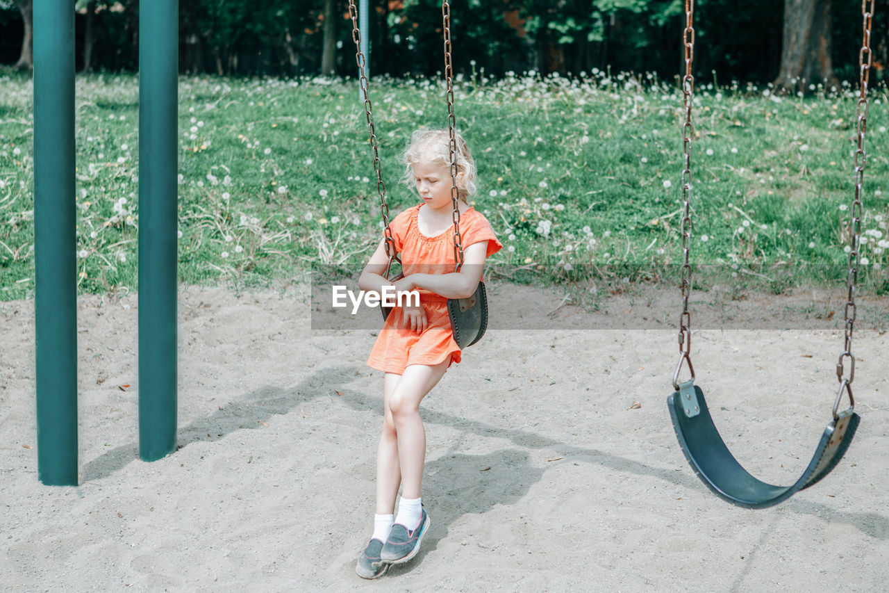 Full length of girl sitting on swing