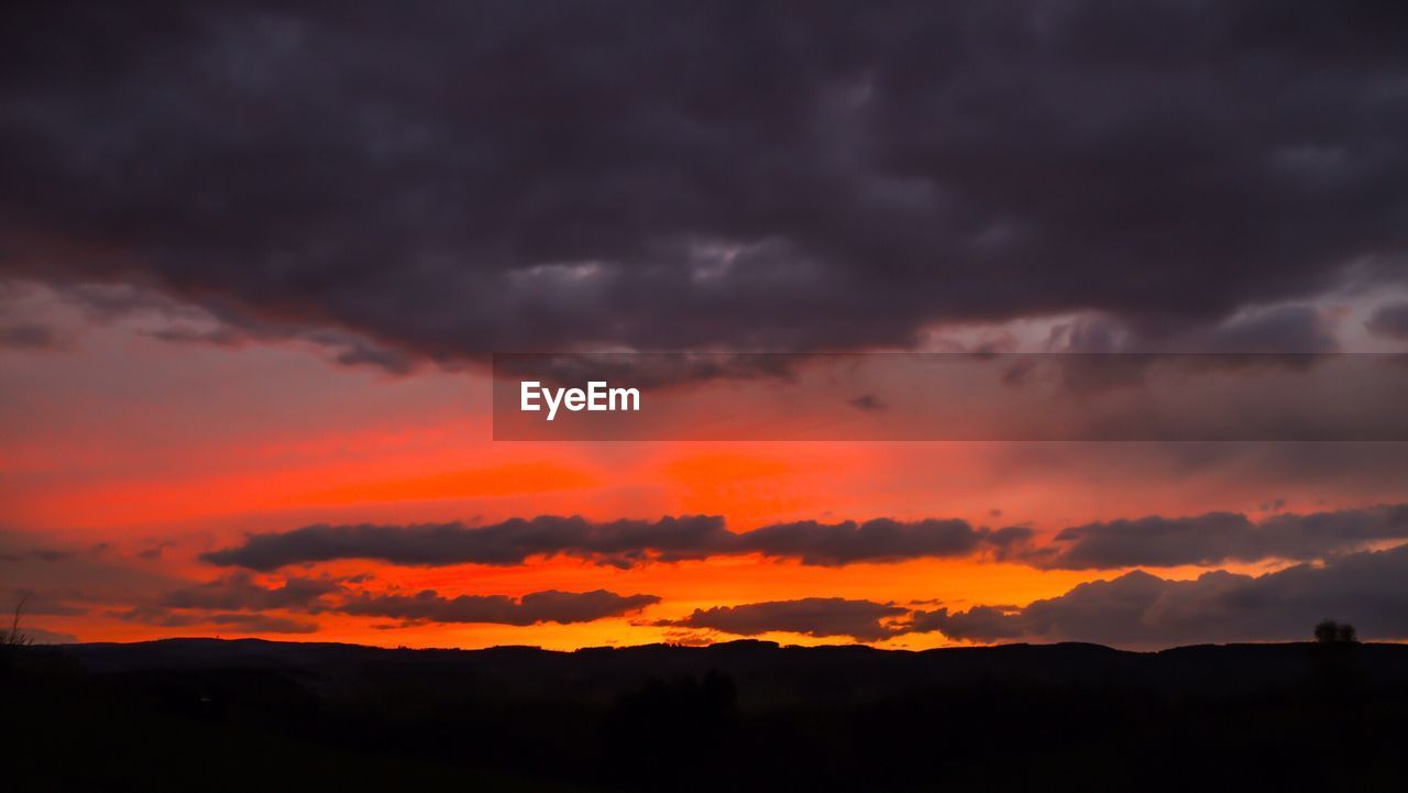 DRAMATIC SKY OVER SILHOUETTE LANDSCAPE