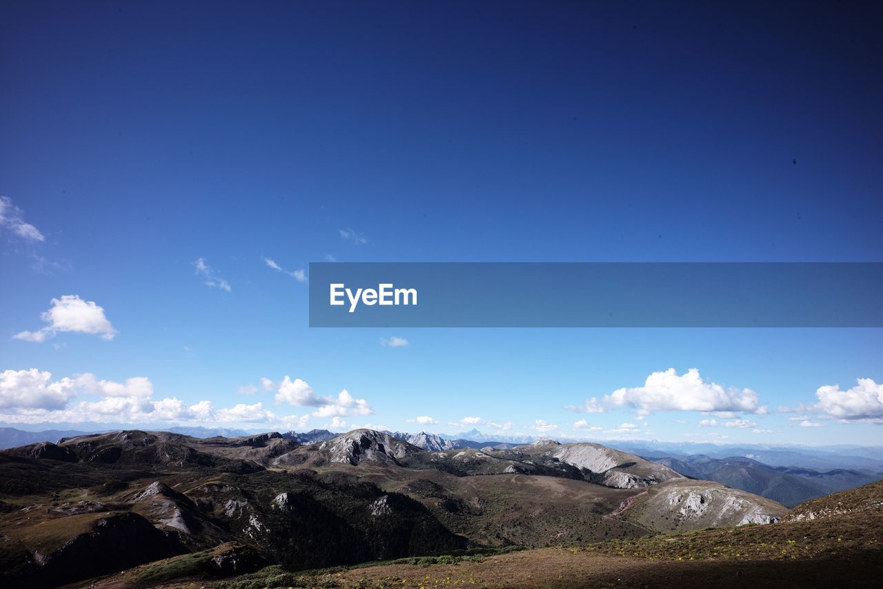 Scenic view of mountains against blue sky