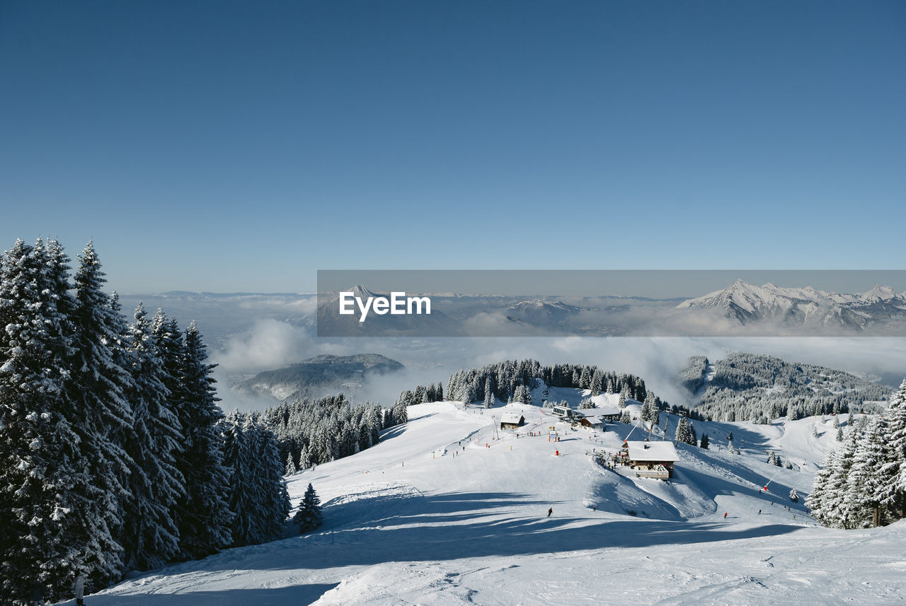 Scenic view of snowcapped mountains against clear blue sky