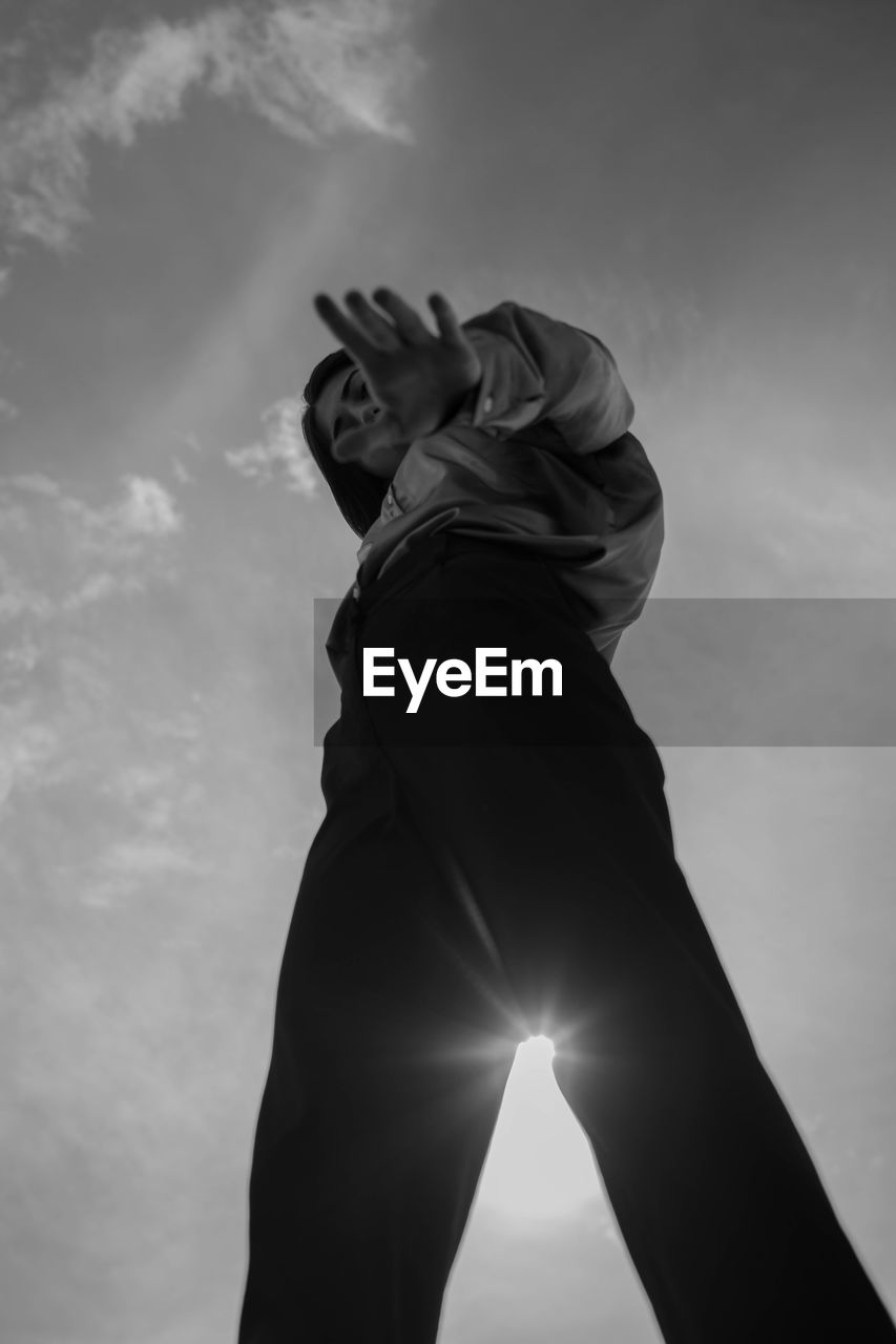 Directly below shot of woman standing against sky