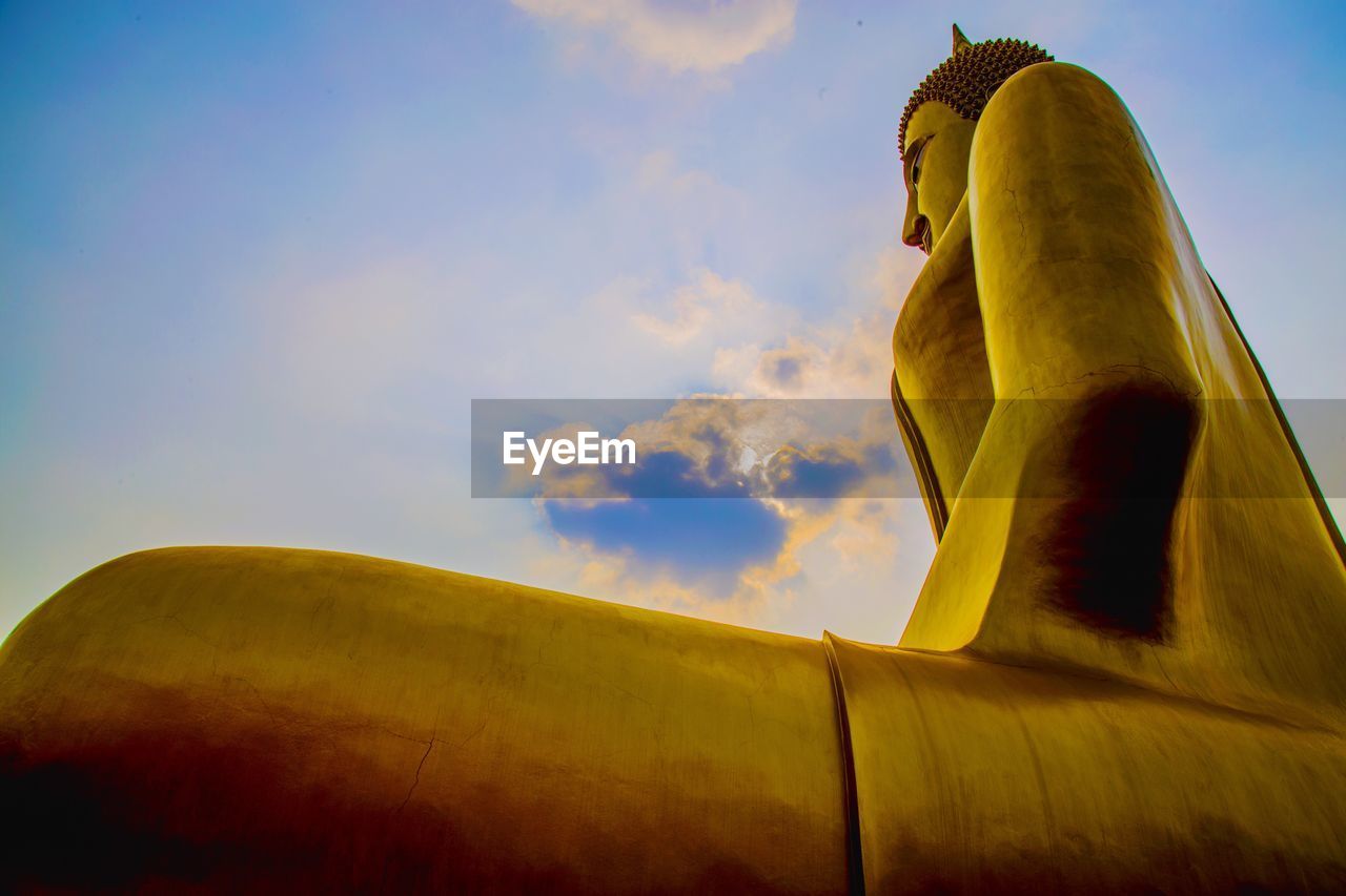 Low angle view of giant buddha statue against sky