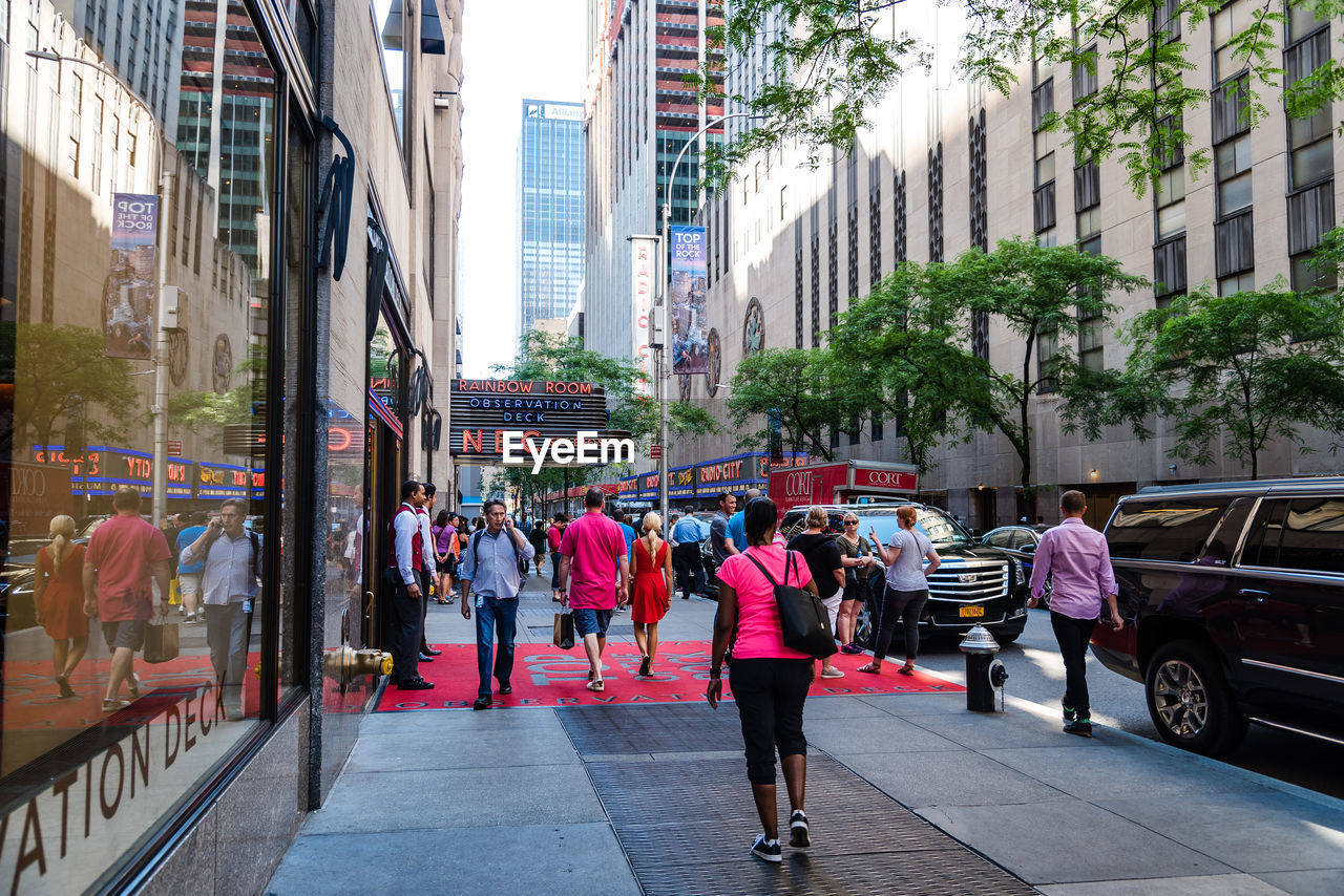 PEOPLE WALKING ON STREET AGAINST BUILDINGS