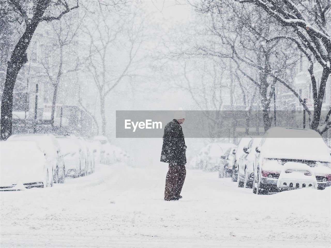 Man walking on snow covered road