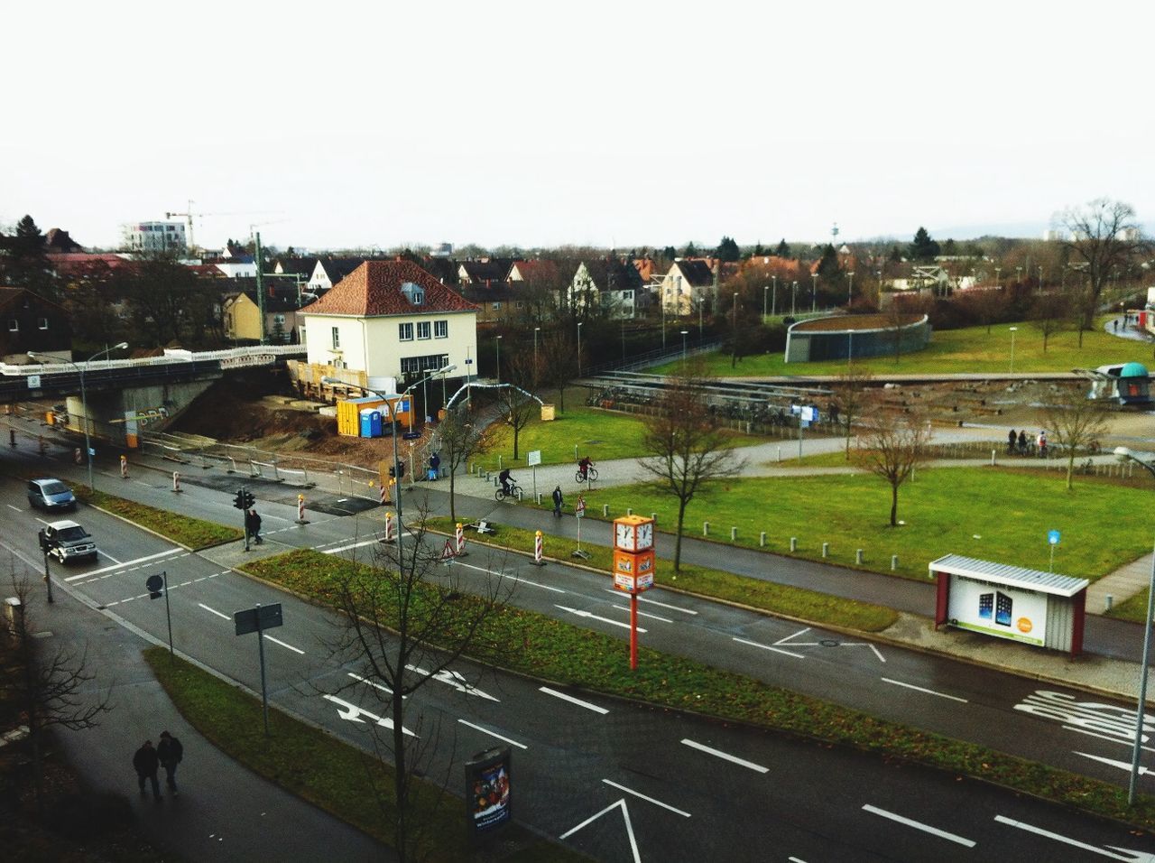 HIGH ANGLE VIEW OF ROAD BY BUILDINGS AGAINST SKY