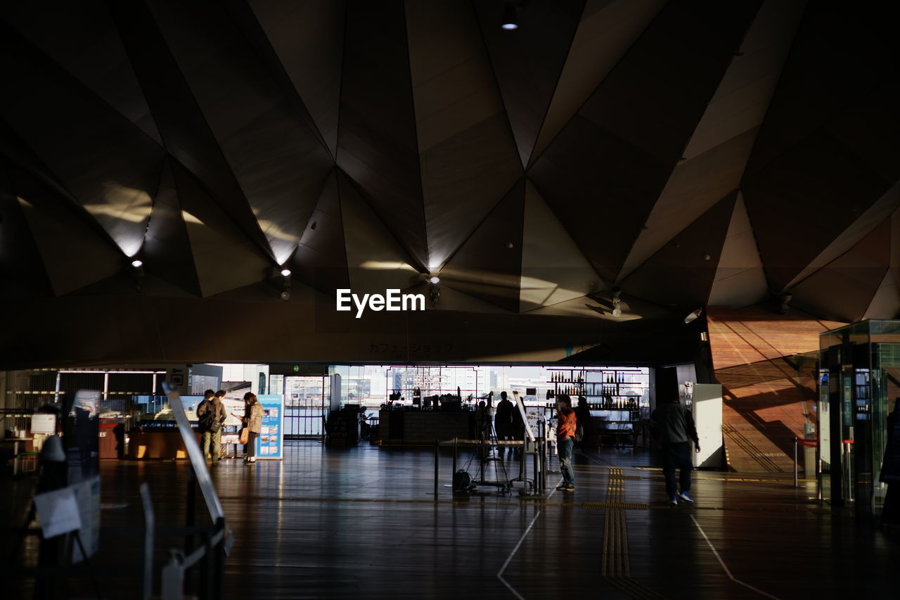 GROUP OF PEOPLE WALKING IN MODERN BUILDING