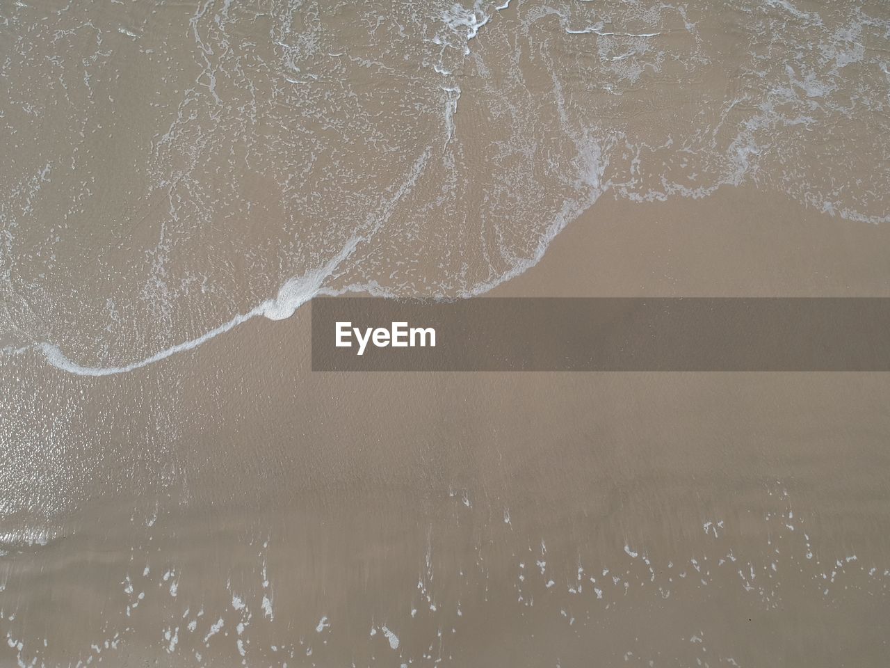 CLOSE-UP OF SEA WAVES SPLASHING ON BEACH