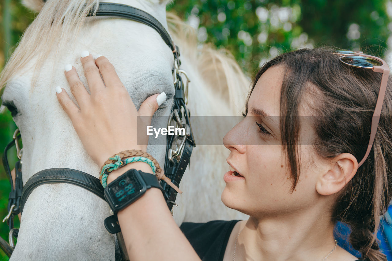 Woman embracing horse on field