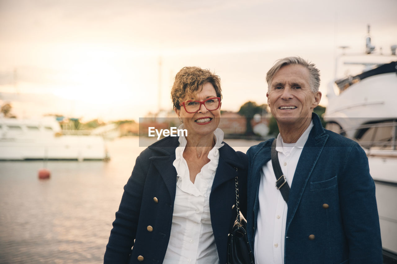 Portrait of confident senior couple smiling at harbor