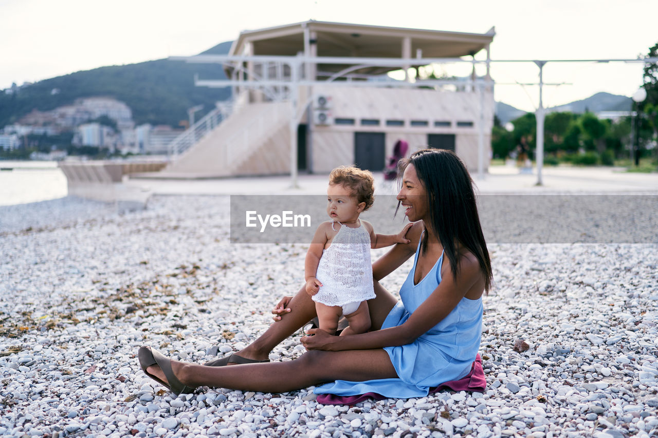 Mother and daughter sitting at beach
