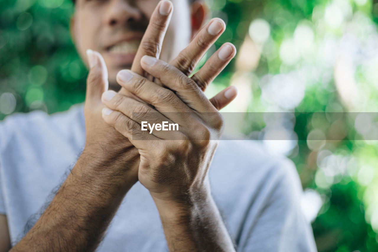 CLOSE-UP OF MAN HAND ON ROCK