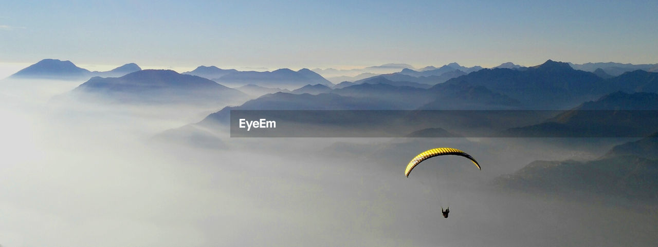 High angle view of person paragliding over mountains