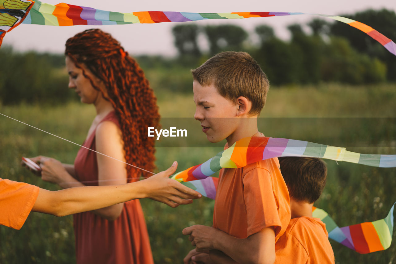 Happy family and children run on meadow with a kite in the summer on the nature.