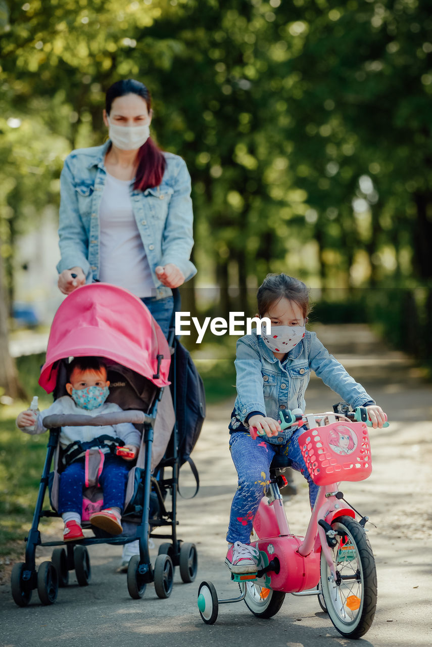 Mother with kids wearing mask walking on street