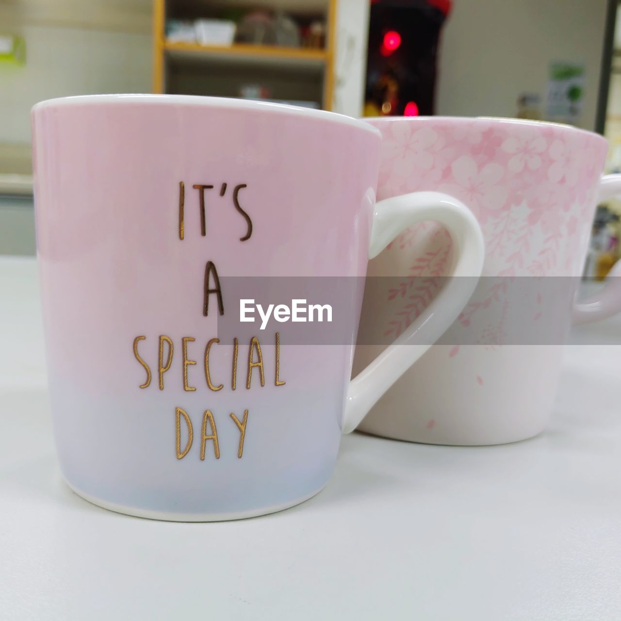 CLOSE-UP OF COFFEE CUP WITH TEXT ON TABLE