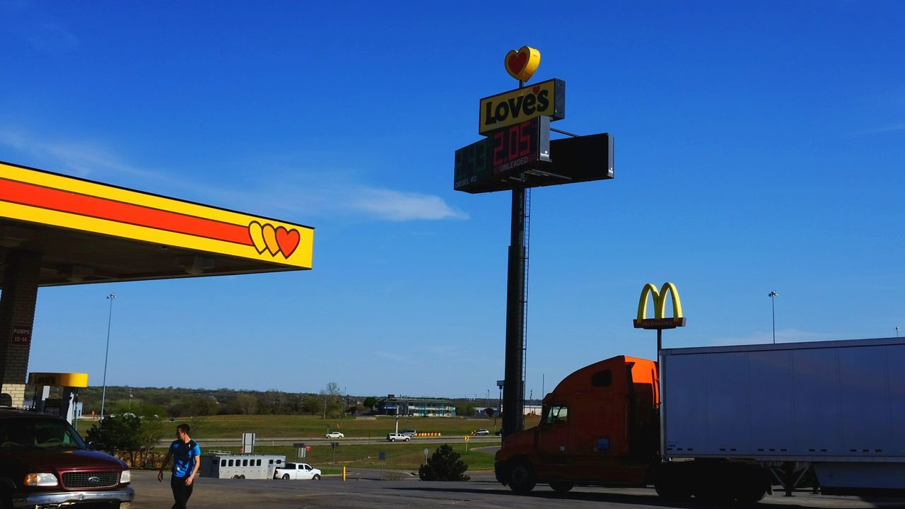 LOW ANGLE VIEW OF ROAD SIGNS AGAINST BLUE SKY