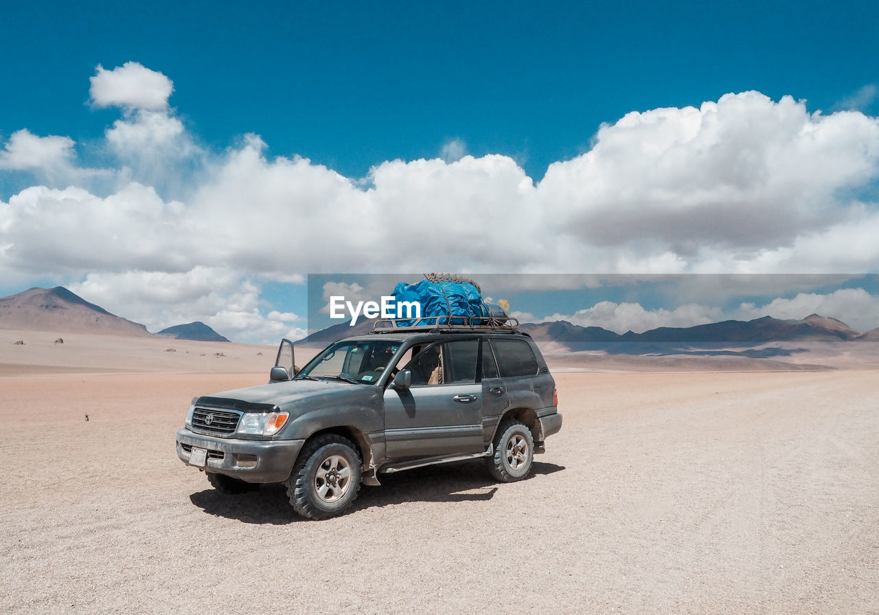 VIEW OF CAR ON DESERT LAND