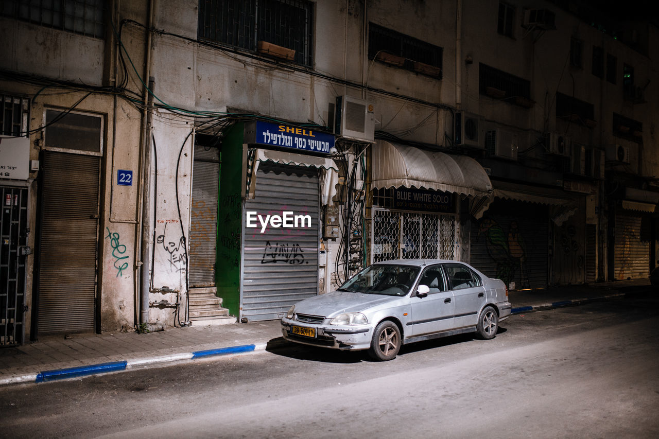 CAR PARKED ON STREET AGAINST BUILDINGS IN CITY