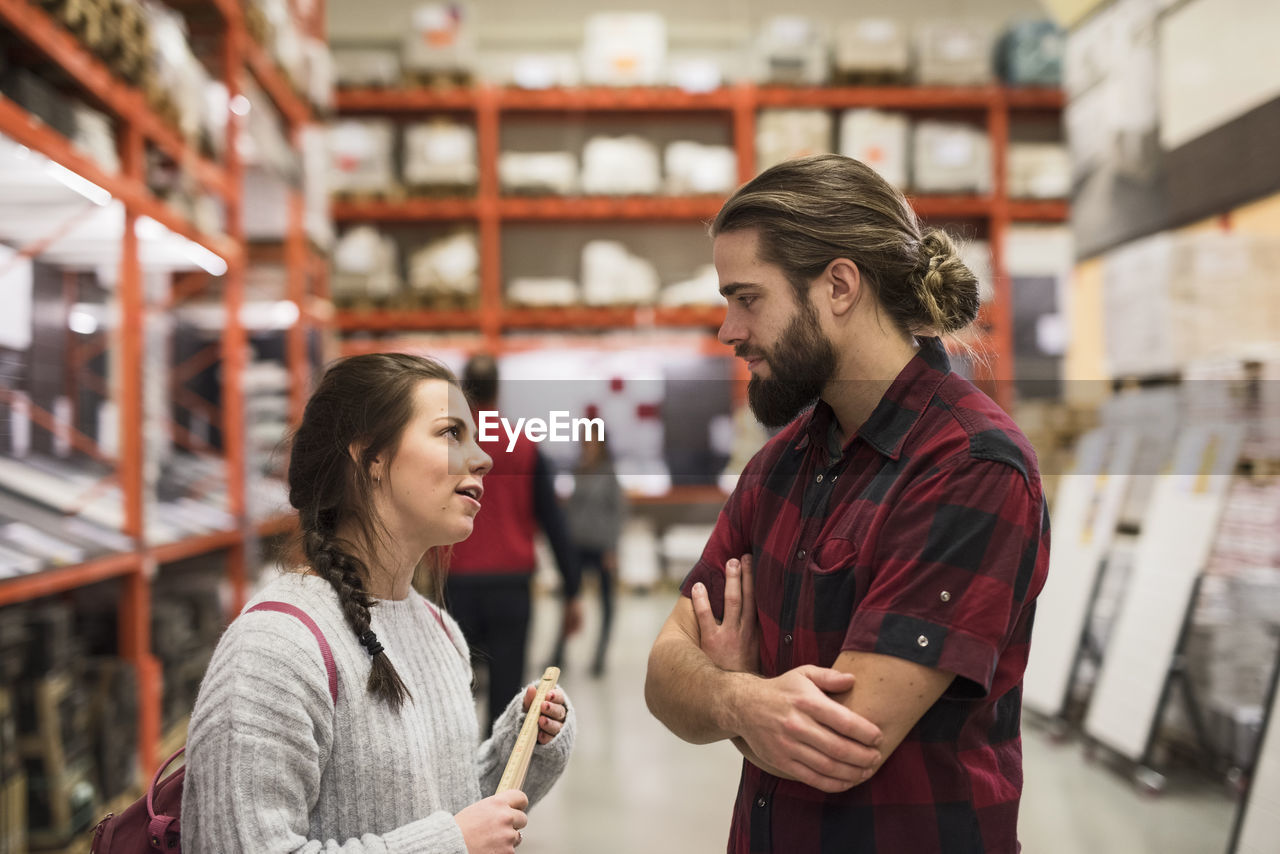 Couple discussing while standing in hardware store