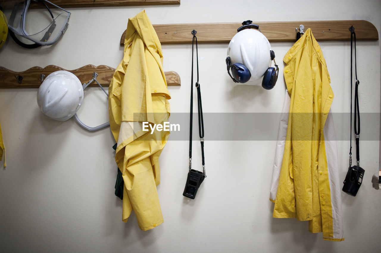 Protective workwear hanging from coat hooks