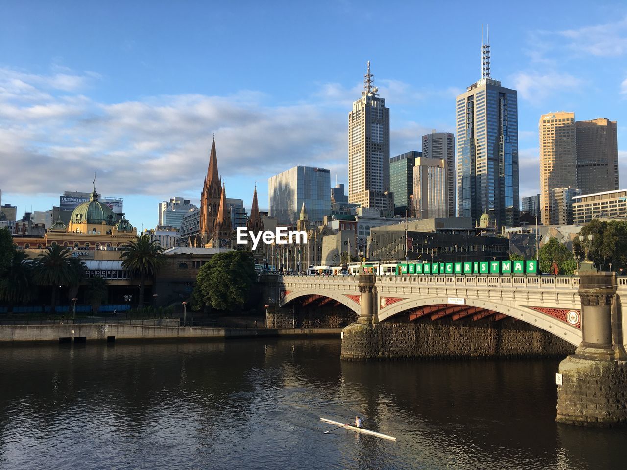 Princes bridge over yarra river by buildings against sky