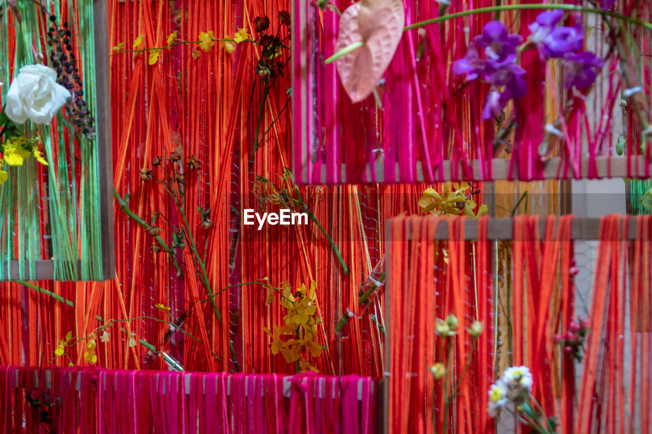 Flowers inserted into weaving.