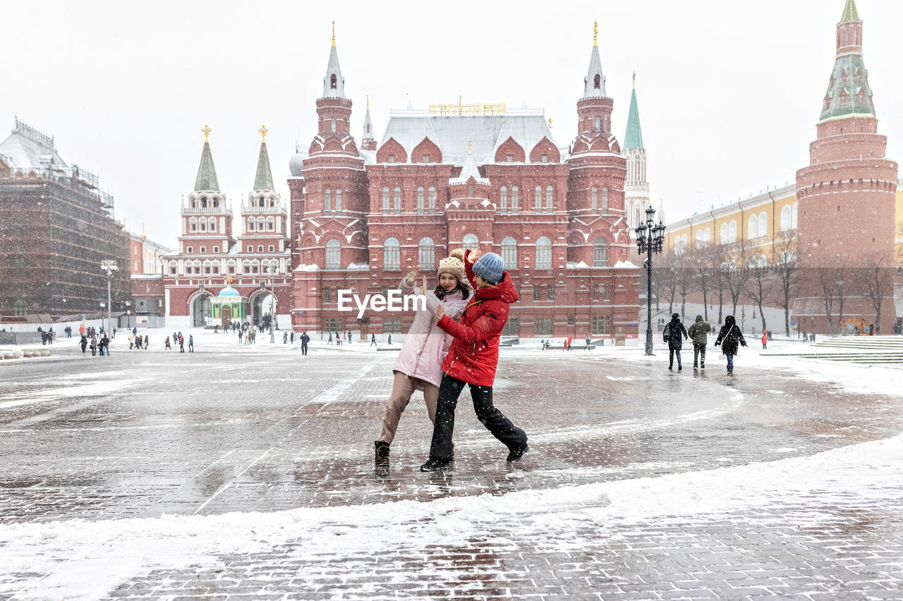 PEOPLE ON SNOW COVERED CITY