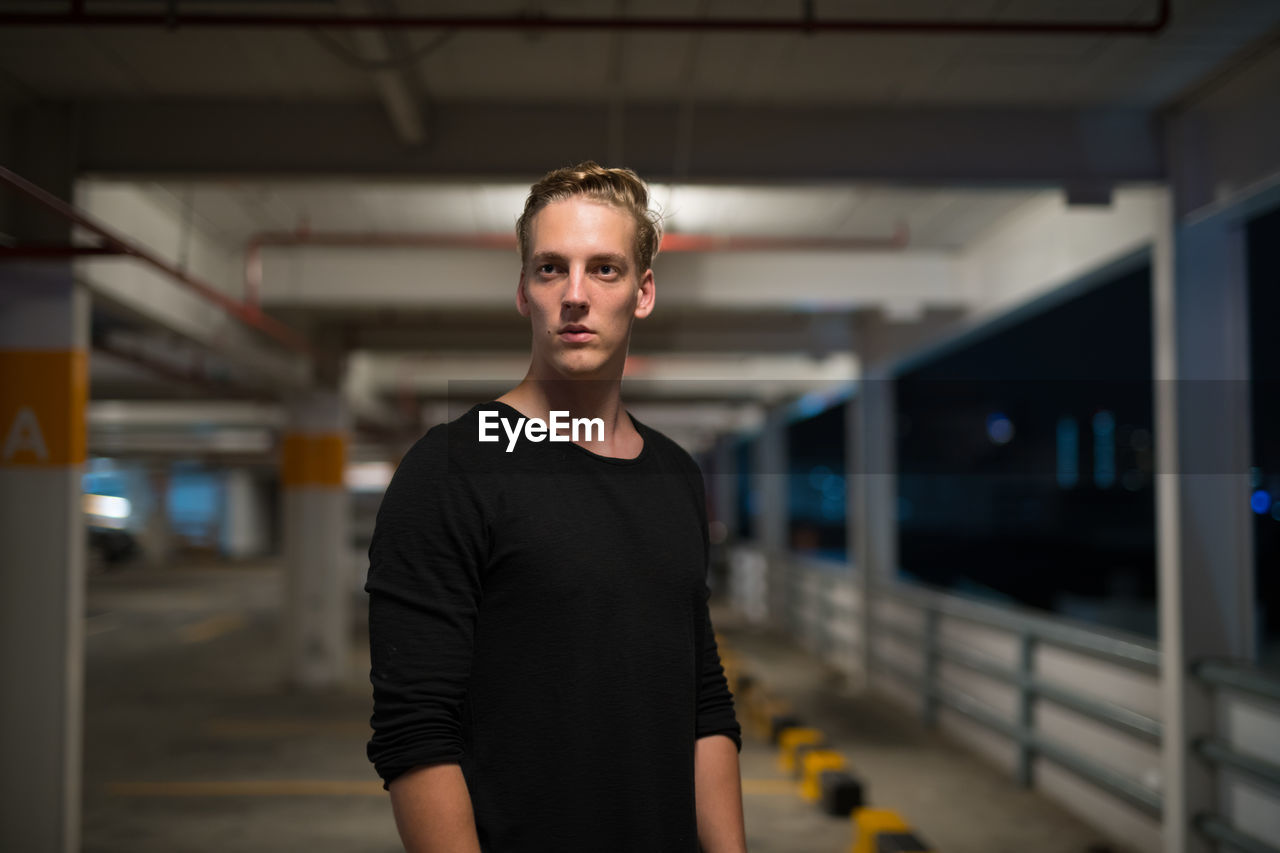 PORTRAIT OF MAN STANDING ON RAILROAD STATION