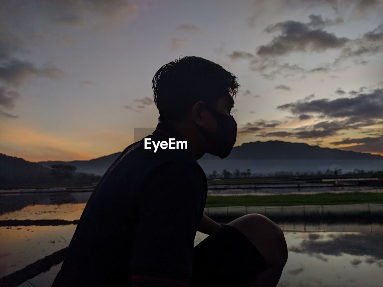 Side view of young man on rice field during sunrise