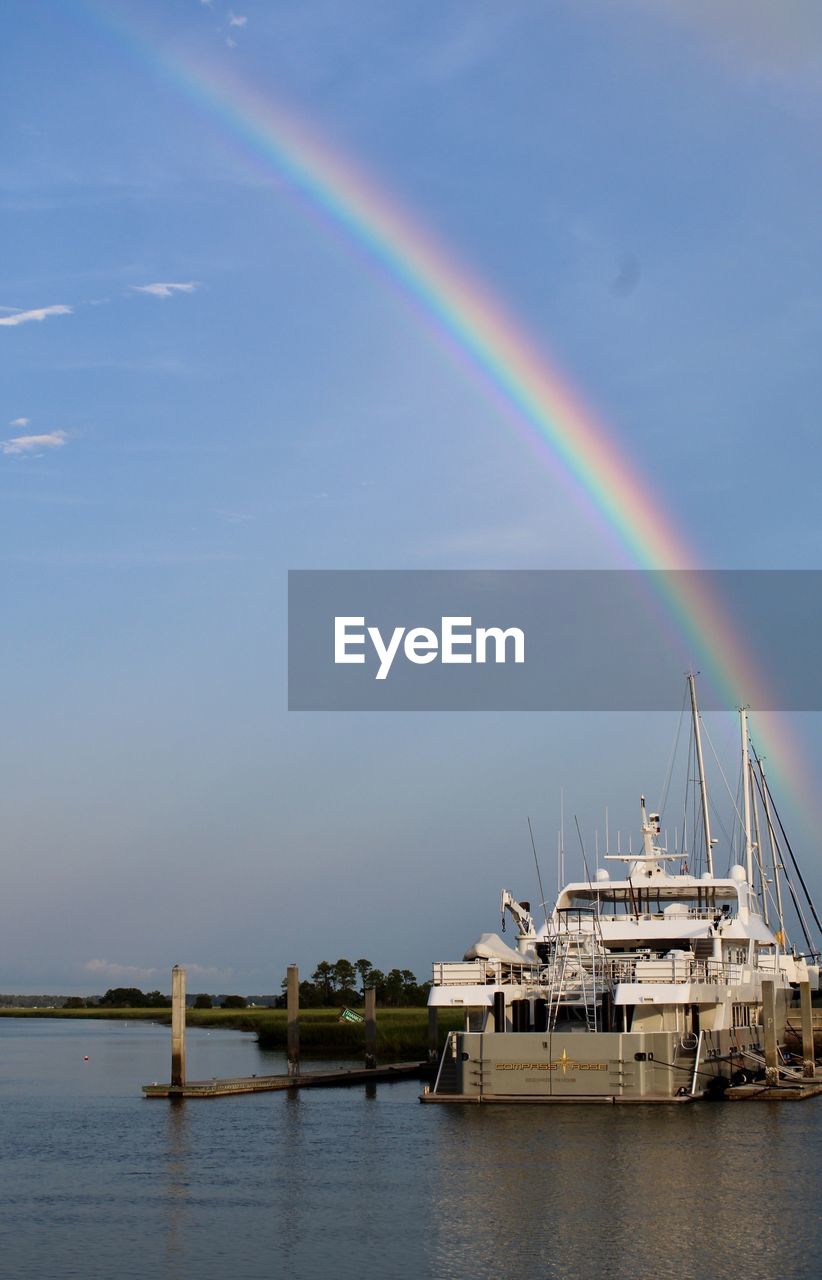 Scenic view of rainbow over sea against sky
