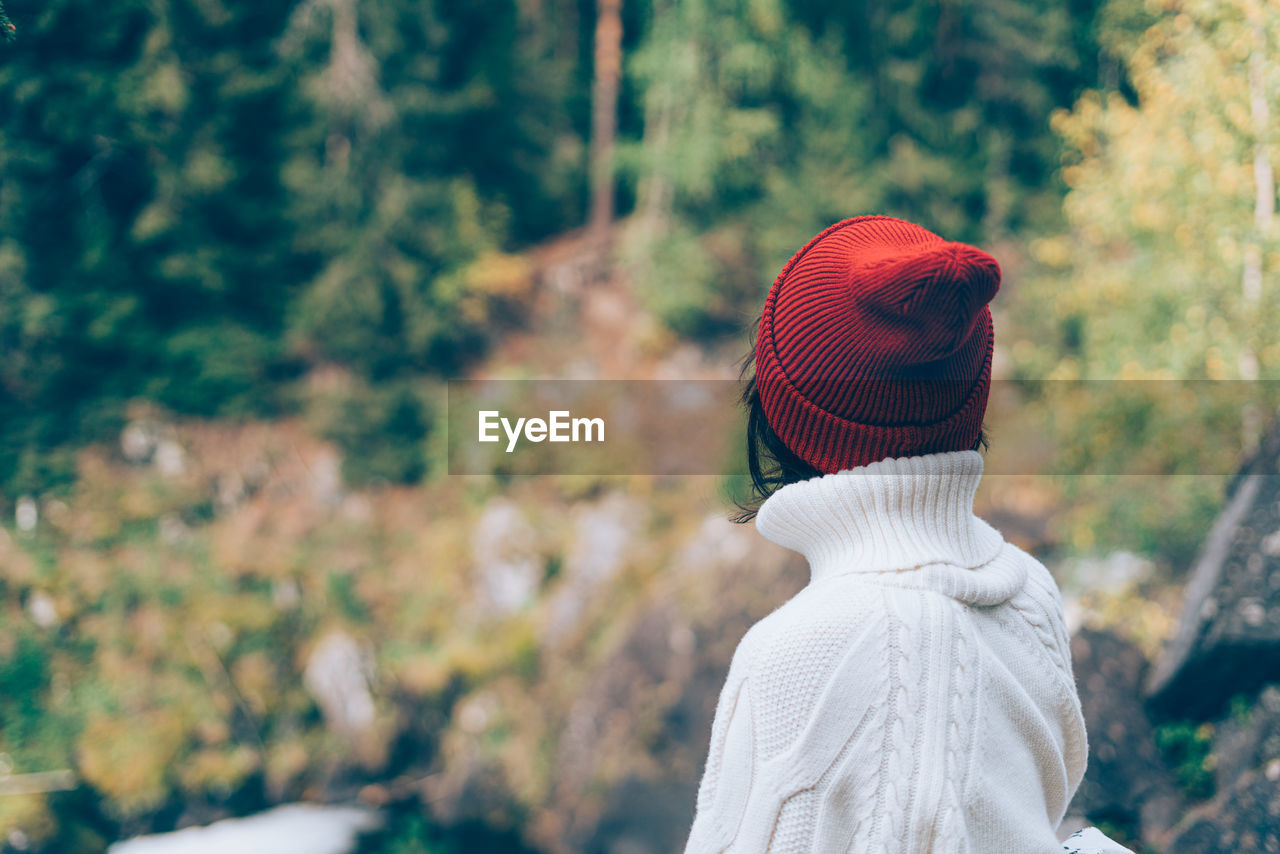 One with nature. back view of unrecognizable woman looking to forest, female in white sweater