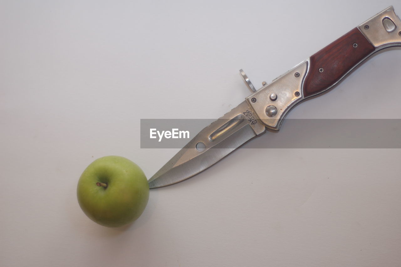 High angle view of granny smith apple with knife on table