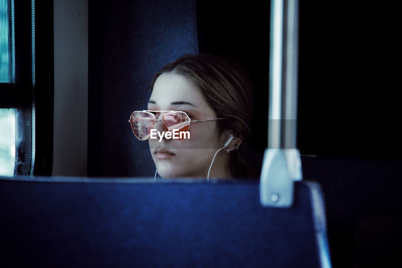Young woman listening music while traveling in train