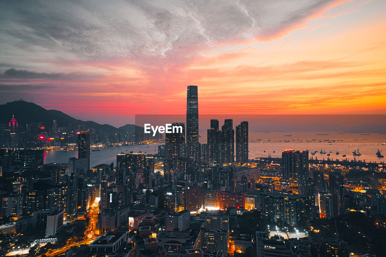 Illuminated buildings against sky during sunset